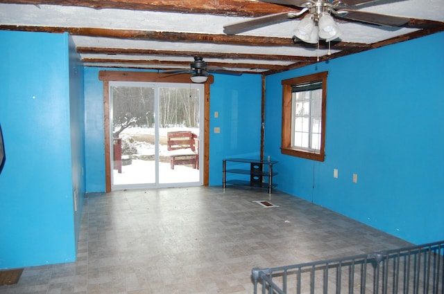 empty room featuring ceiling fan and beam ceiling