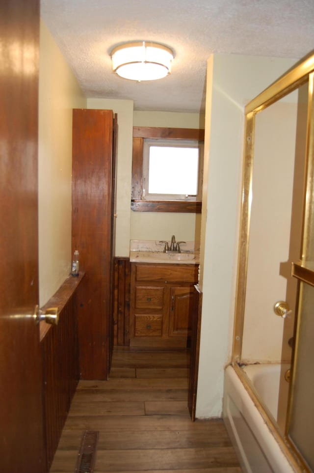 bathroom with shower / bath combination, hardwood / wood-style floors, vanity, and a textured ceiling