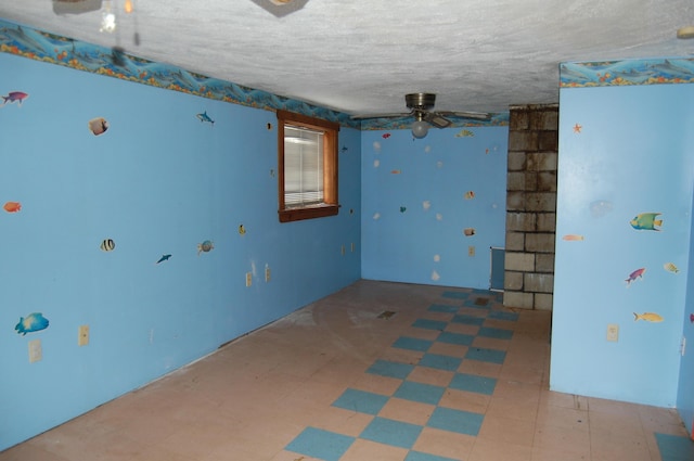 empty room featuring ceiling fan and a textured ceiling