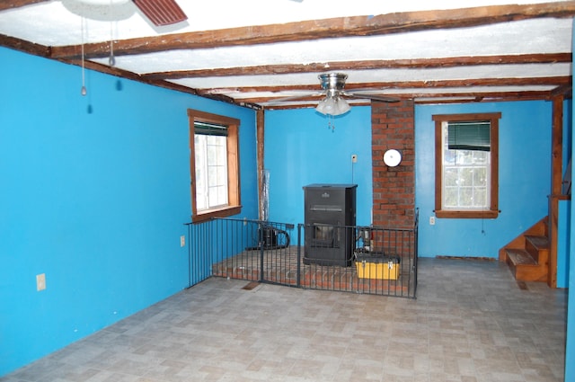 living room with beam ceiling and a wood stove