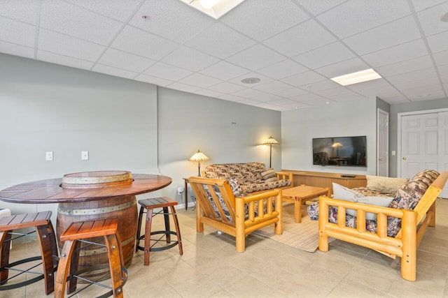 tiled living room featuring a paneled ceiling