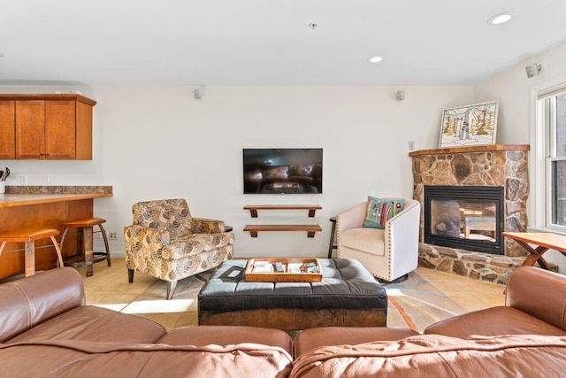 tiled living room with a stone fireplace