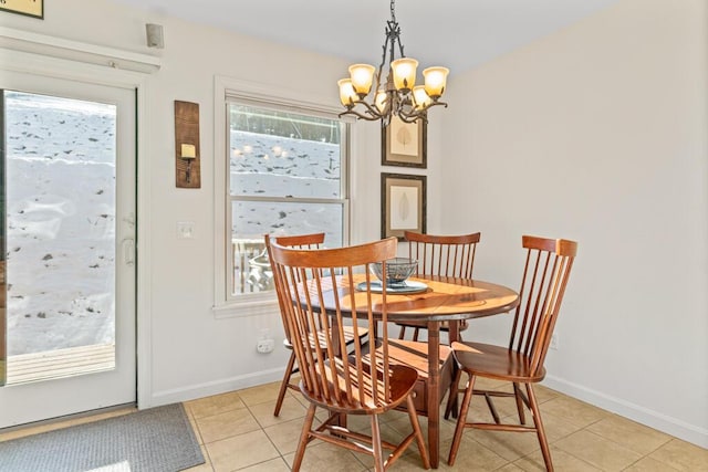 tiled dining area featuring a healthy amount of sunlight and a notable chandelier