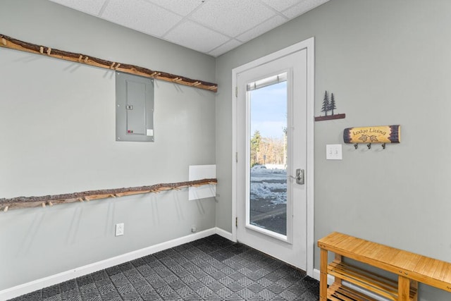 entryway with electric panel, a paneled ceiling, and dark tile patterned flooring