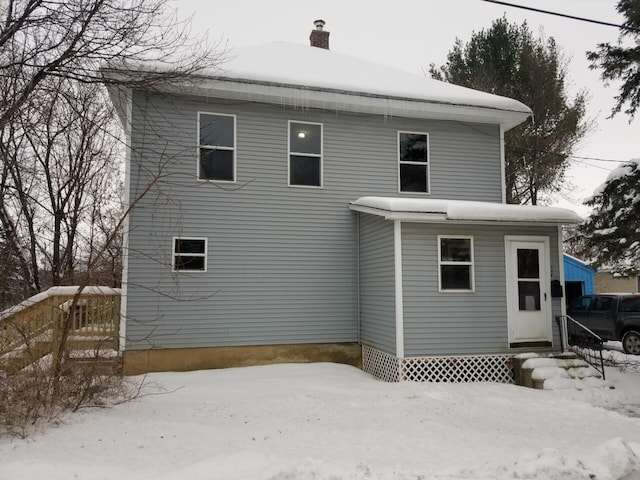 view of snow covered rear of property