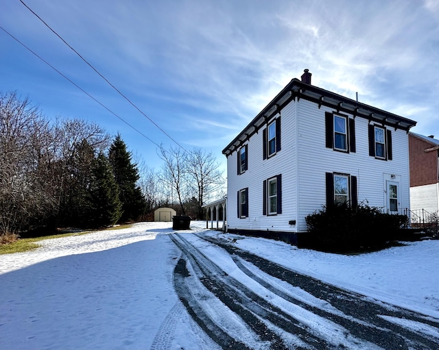 view of snowy exterior featuring a storage unit