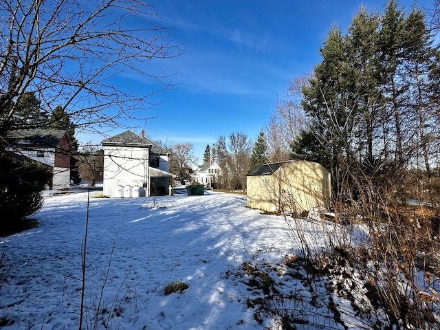 yard layered in snow with a storage unit