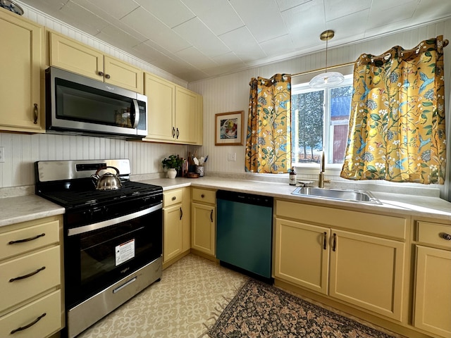 kitchen featuring appliances with stainless steel finishes, sink, and pendant lighting