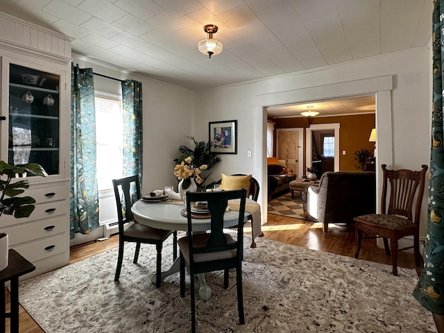 dining area with crown molding and light hardwood / wood-style floors