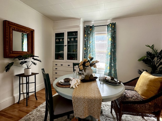 dining space featuring ornamental molding and wood-type flooring