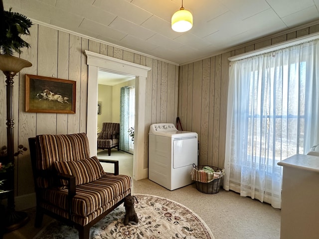 living area featuring washer / dryer and wooden walls