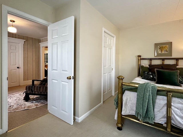 carpeted bedroom with wood walls