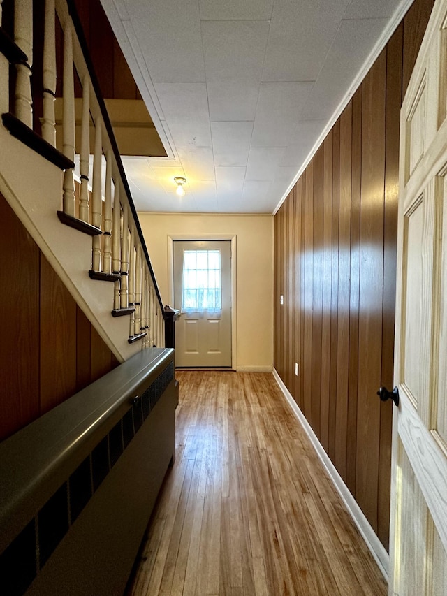 doorway to outside with hardwood / wood-style floors and wood walls