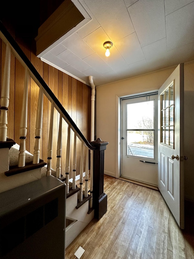 stairs featuring wood-type flooring and wood walls