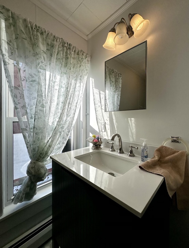 bathroom featuring vanity, a baseboard heating unit, and crown molding