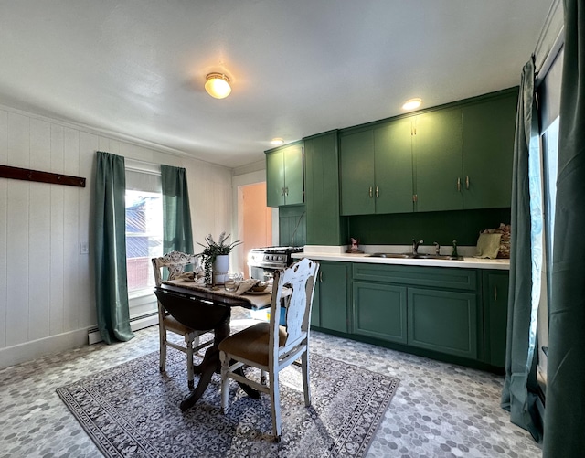 kitchen featuring a baseboard heating unit, sink, and green cabinetry