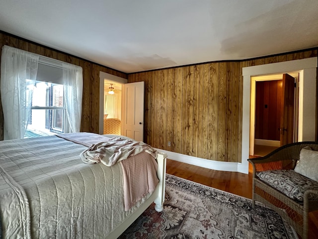 bedroom with hardwood / wood-style floors and wooden walls