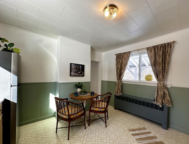 dining room with radiator and light carpet