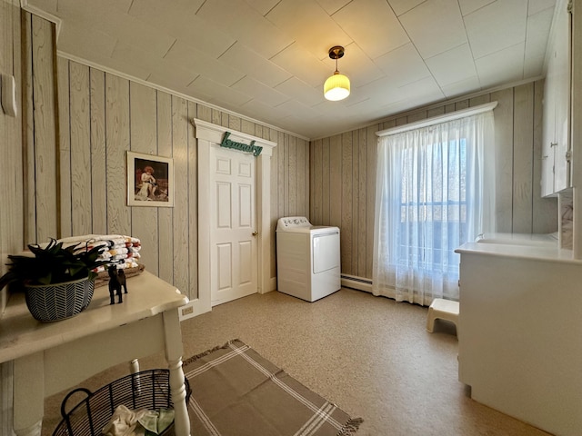 washroom with a baseboard radiator, washer / dryer, and wood walls