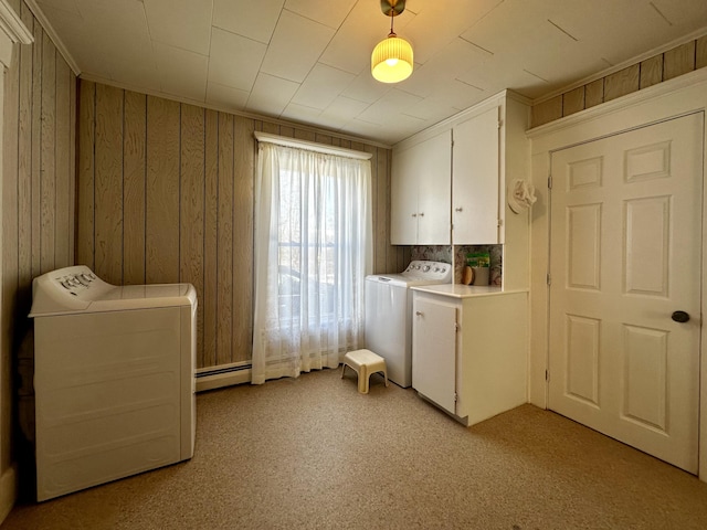 laundry room with cabinets, washer and dryer, baseboard heating, and wood walls