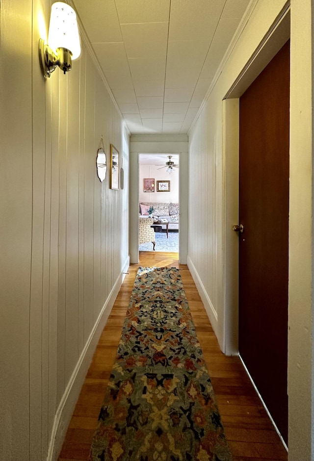 hallway featuring hardwood / wood-style flooring and ornamental molding