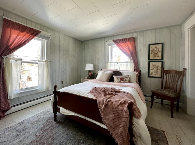 bedroom featuring multiple windows and a baseboard heating unit