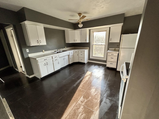 kitchen with white cabinets, sink, ceiling fan, white fridge, and range