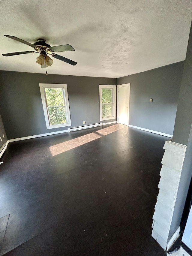 spare room featuring ceiling fan, a textured ceiling, and a baseboard heating unit