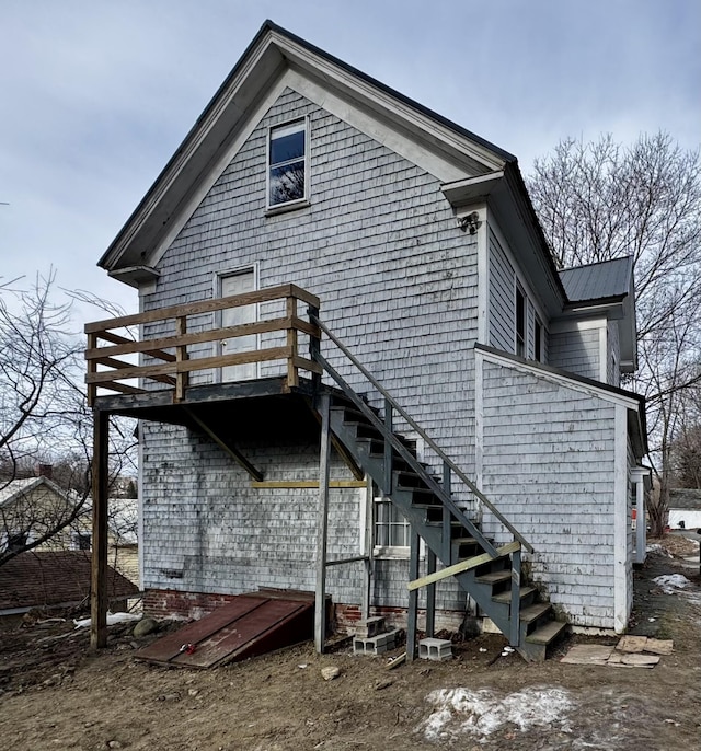 back of house with stairs and metal roof