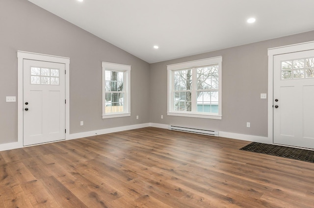 entryway with lofted ceiling, a baseboard heating unit, and hardwood / wood-style floors