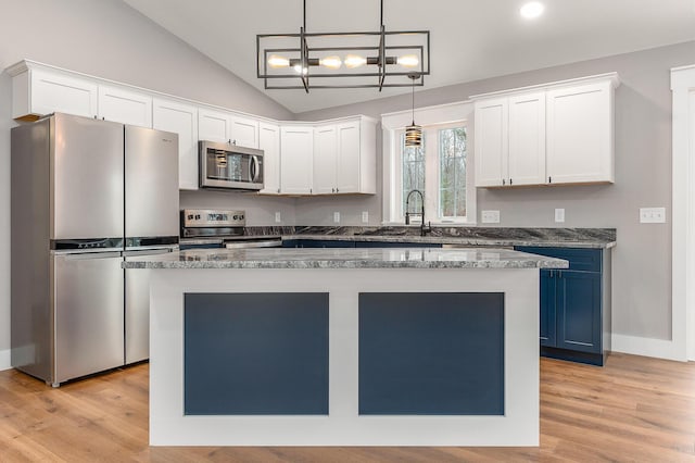 kitchen featuring a center island, hanging light fixtures, stainless steel appliances, blue cabinetry, and white cabinets