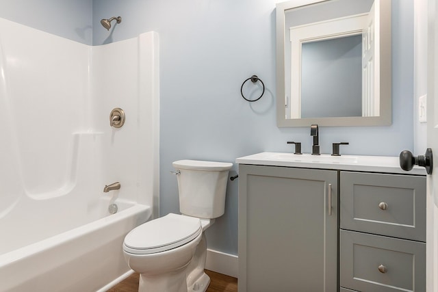 full bathroom featuring toilet, hardwood / wood-style flooring, washtub / shower combination, and vanity