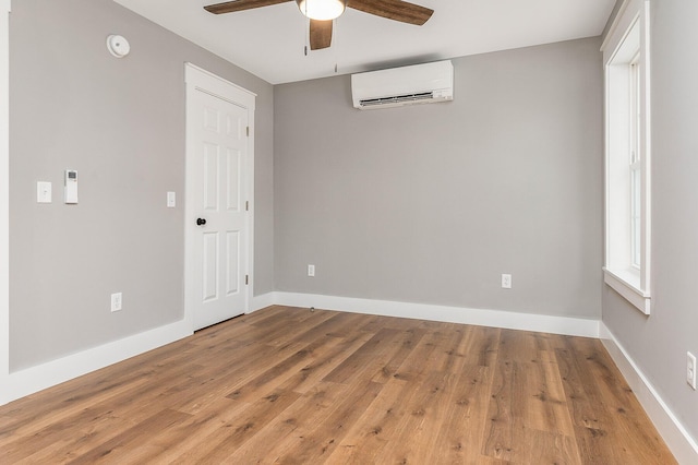 empty room featuring hardwood / wood-style floors, ceiling fan, and a wall mounted AC