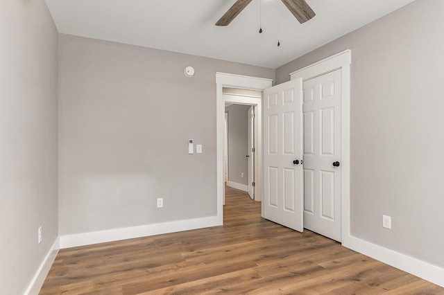 unfurnished bedroom featuring wood-type flooring, a closet, and ceiling fan