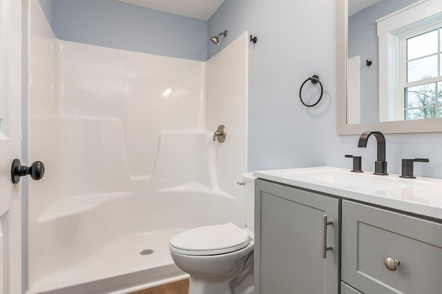 bathroom with toilet, wood-type flooring, walk in shower, and vanity