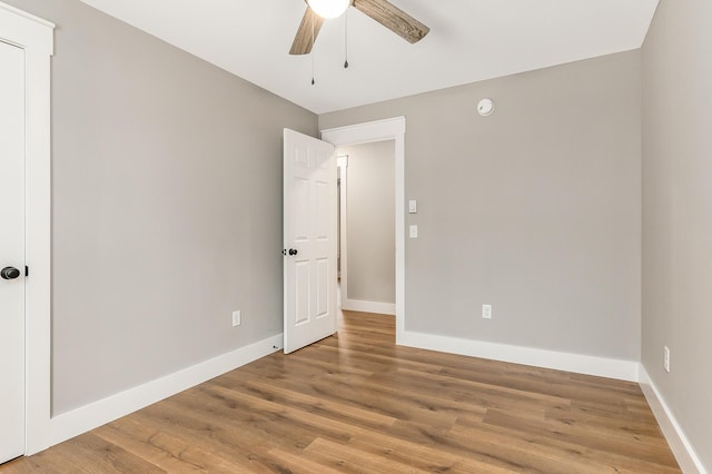 empty room with ceiling fan and hardwood / wood-style flooring