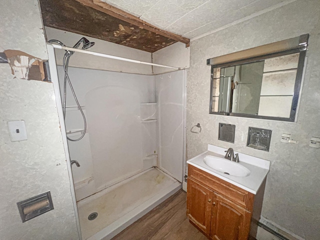 bathroom featuring crown molding, vanity, wood-type flooring, and walk in shower