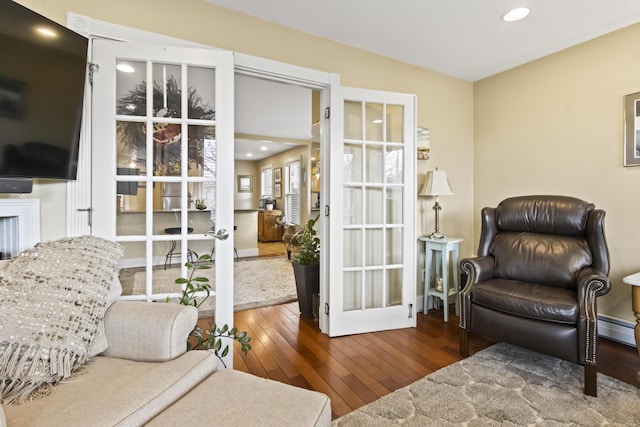 sitting room with dark hardwood / wood-style flooring, a baseboard radiator, and french doors