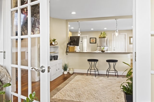 kitchen featuring decorative light fixtures, stainless steel fridge, wood-type flooring, and french doors