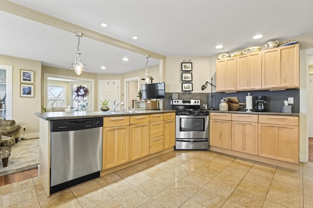 kitchen with light brown cabinets, stainless steel appliances, hanging light fixtures, and sink