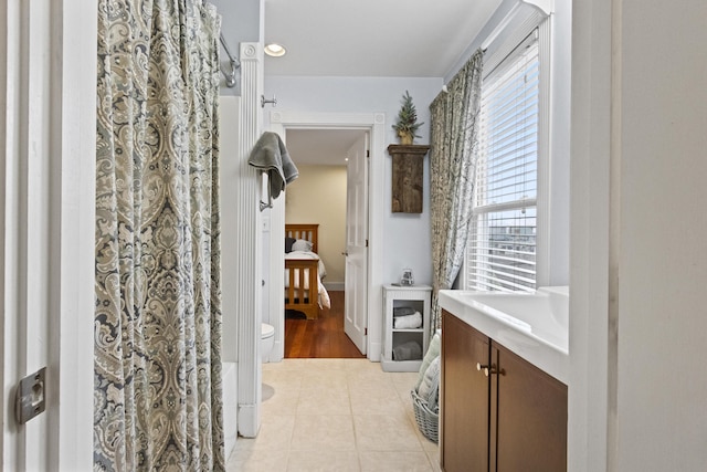 bathroom with toilet, vanity, and tile patterned floors