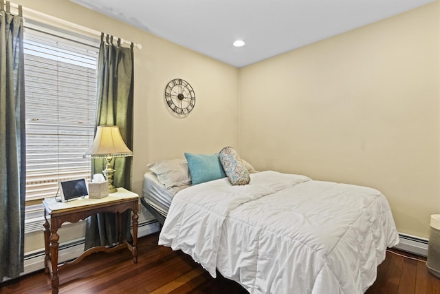 bedroom featuring multiple windows, dark wood-type flooring, and a baseboard radiator