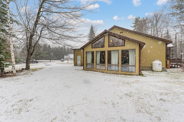 view of snow covered back of property