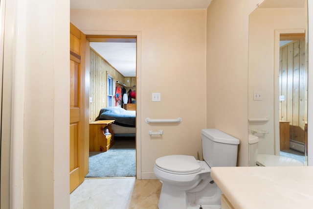 bathroom featuring vanity, toilet, and a baseboard heating unit