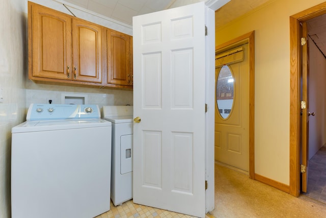 clothes washing area featuring cabinets and separate washer and dryer