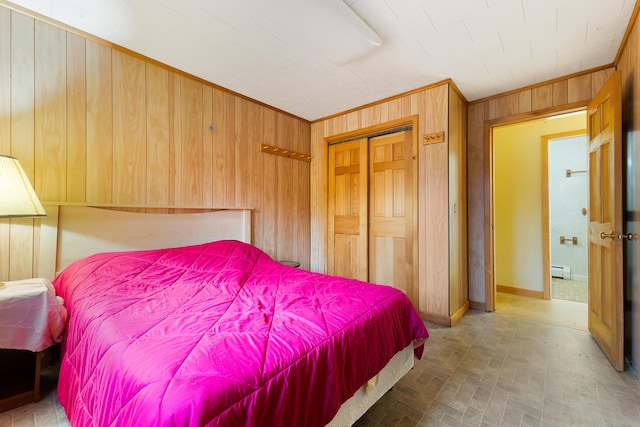 bedroom with a baseboard radiator, crown molding, a closet, and wooden walls