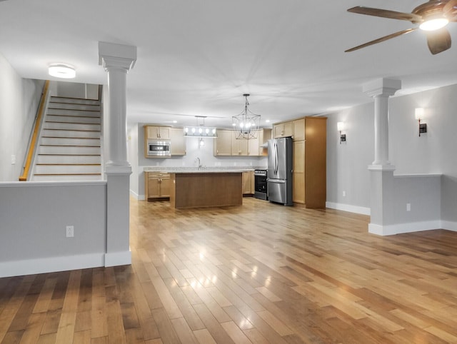 kitchen with pendant lighting, a center island, ceiling fan with notable chandelier, light hardwood / wood-style flooring, and appliances with stainless steel finishes