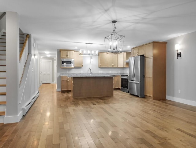 kitchen featuring baseboard heating, an island with sink, light wood-type flooring, and appliances with stainless steel finishes