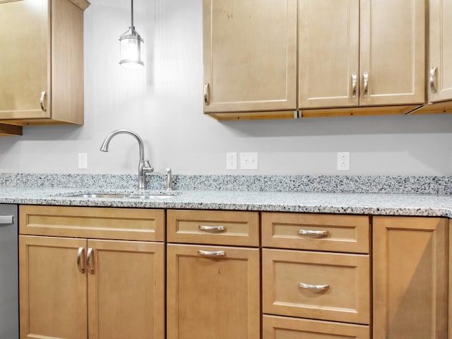 kitchen featuring dishwasher, decorative light fixtures, light stone counters, and sink