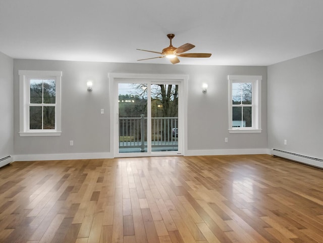 spare room with a baseboard radiator, light hardwood / wood-style flooring, and a wealth of natural light